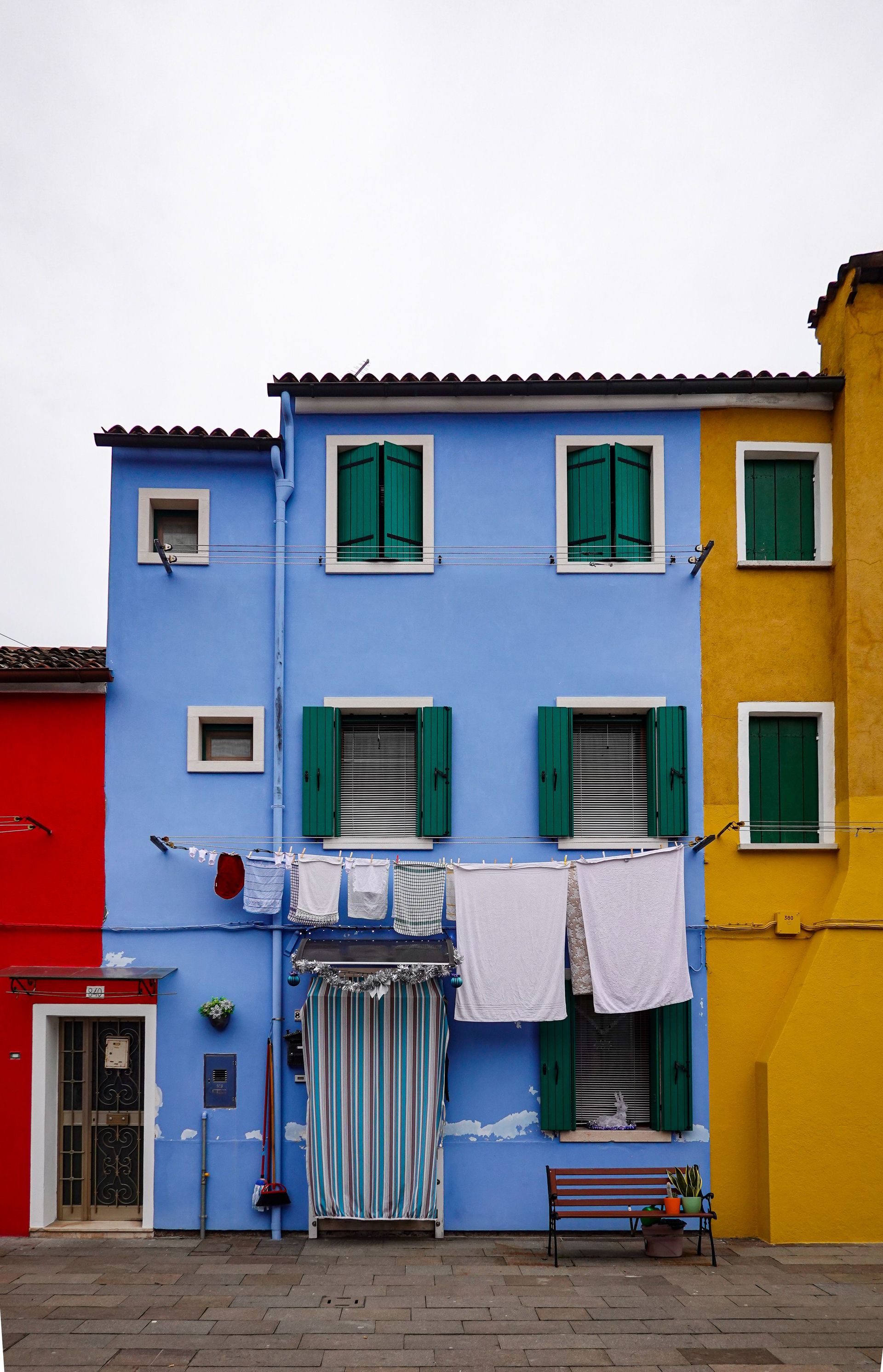Brightly colored houses with laundry in a lively street, showcasing vibrant architecture